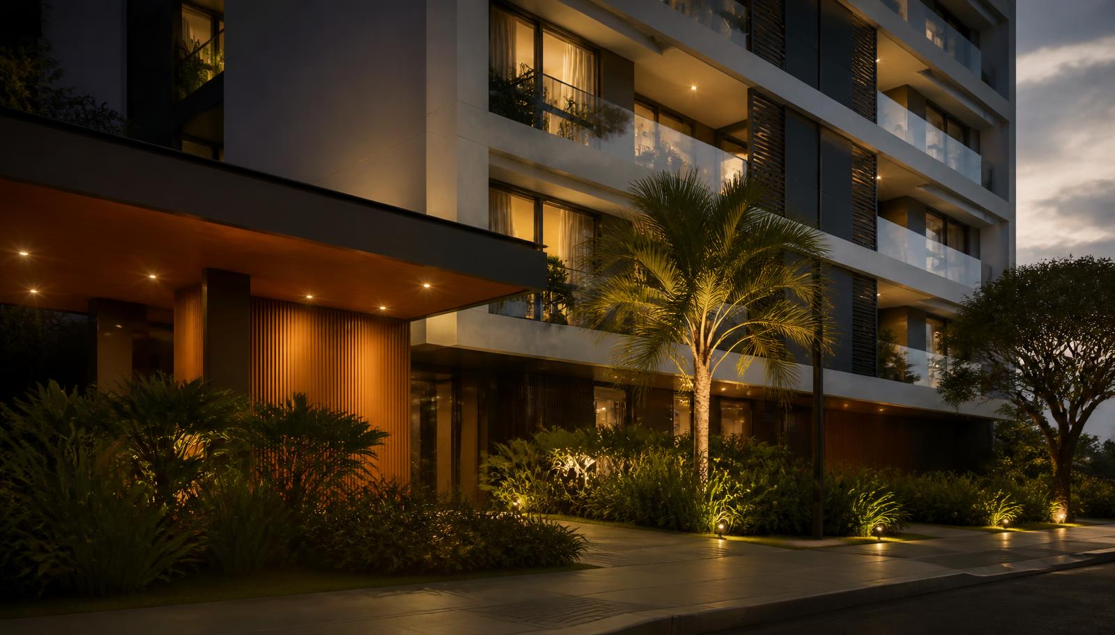 Fachada de condomínio residencial moderno ao entardecer, com iluminação quente e jardim